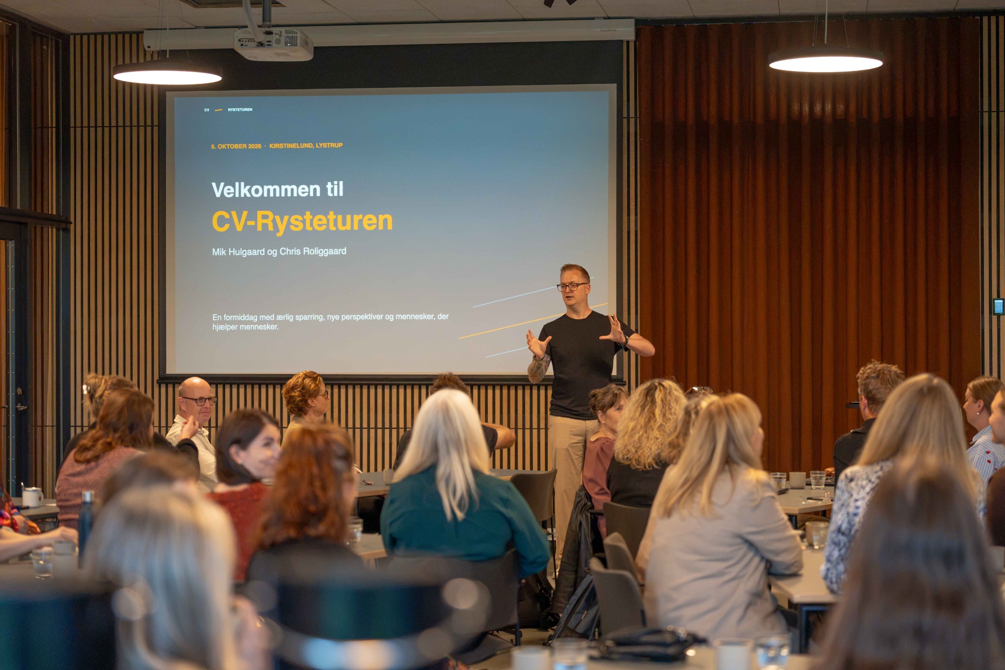 Chris står foran deltagerne og præsenterer CV-Rysteturen